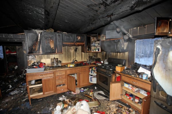 A kitchen that has been burned and is in the middle of fire.