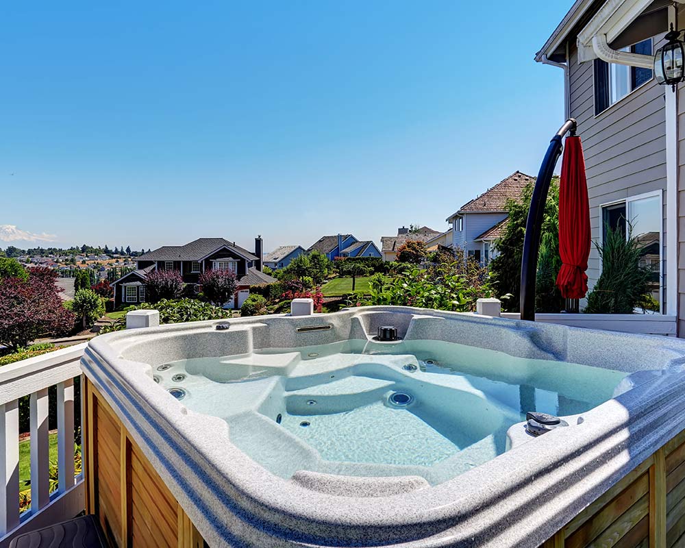 A hot tub in the middle of a yard.